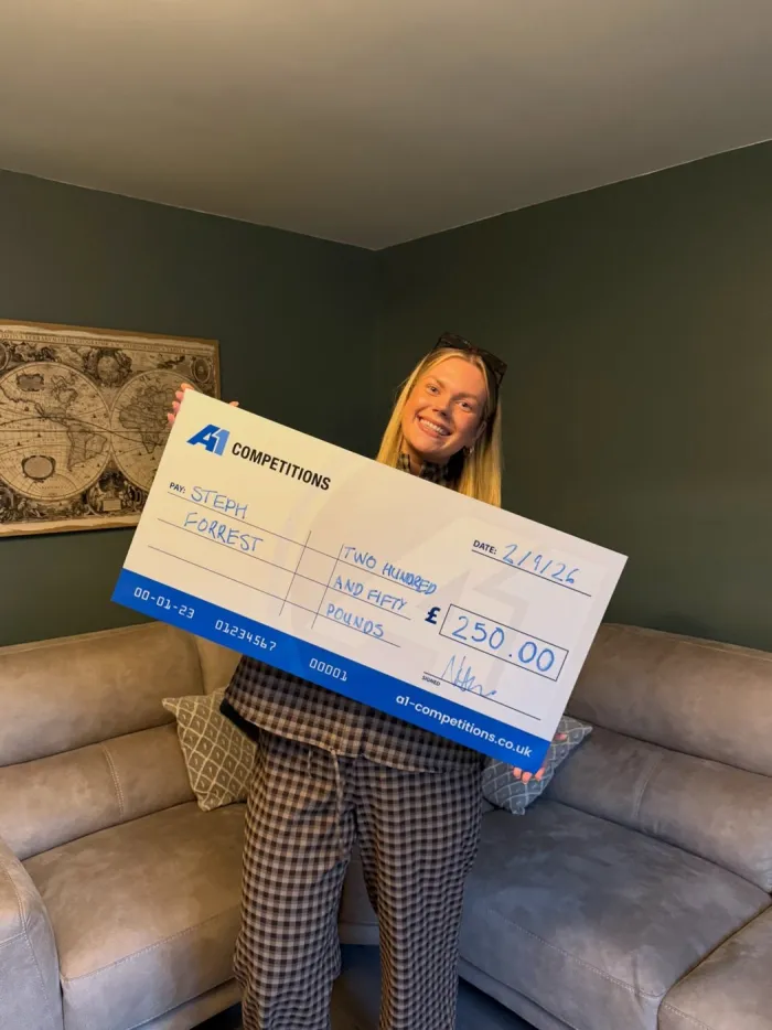 A1 Competitions winner holding a WINNER sign